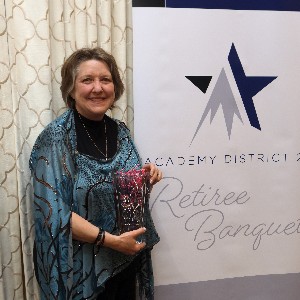 Debbie Saccolitti smiles a for picture with her vase at the 2023 Retiree Banquet